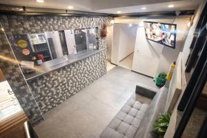 a restaurant with a counter and a tile wall at HOTEL MEDELLIN CENTRAL in Medellín