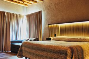 a bedroom with two beds and a couch and a window at Complejo Piuquenes Valle de Uco in Vista Flores
