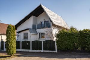 a white house with a fence in front of it at Dom Czajka nad Jeziorem Wigry in Stary Folwark
