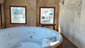 a bath tub in a bathroom with two windows at Empire Hotel Buenos Aires in Buenos Aires
