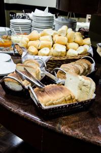 a table topped with two baskets of bread and sandwiches at Hotel Casimiro in Ponta Grossa