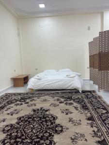 a bedroom with a bed and a rug at Adam House in Ghardaïa