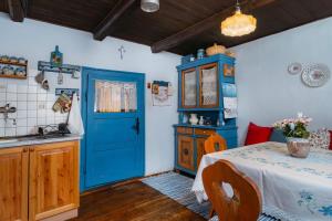 a kitchen with a blue door and a table at Chalupa na Samote in Terchová +33 photos