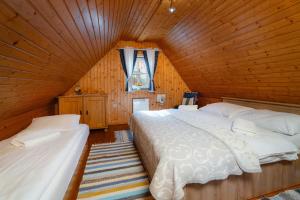 a bedroom with two beds in a wooden room at Chalupa na Samote in Terchová