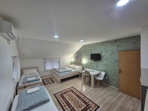a room with two beds and a table and a couch at Apartments City Paradise in Mostar
