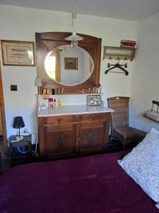 a bedroom with a bed and a vanity with a mirror at Vakantiehuis Malaika in Rendeux +18 photos