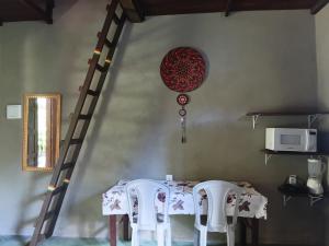a dining room with a table and two chairs at Recanto BantuArte-Boipeba in Cairu