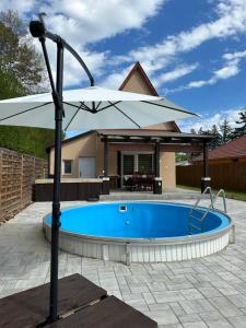 a large white umbrella next to a swimming pool at KörösPartOn in Békésszentandrás