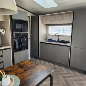 a kitchen with a wooden table and a sink and a stove at 10 Sunset view in Scunthorpe +4 photos