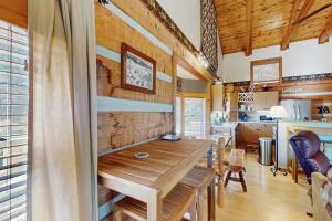 a dining room with a wooden table and a kitchen at Napping Bear Cabin in Banner Elk