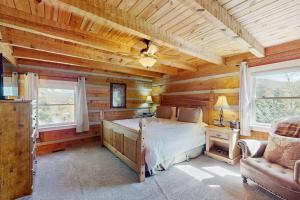 a bedroom with a bed and a couch and two windows at Napping Bear Cabin in Banner Elk