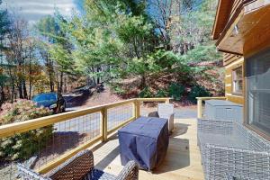 a patio with a table and chairs on a porch at Napping Bear Cabin in Banner Elk