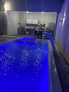 a swimming pool with blue lighting in a kitchen at Casa do Arruda na tabuba in Caucaia