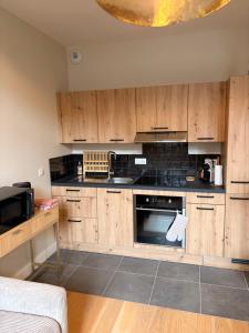 a kitchen with wooden cabinets and a stove top oven at Ninon et ses sommets in Cauterets +27 photos