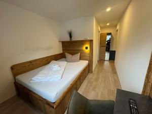 a small bedroom with a bed with white sheets at Landhotel Zum Hirsch in Unterweißbach