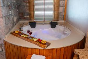 a bath tub with wine glasses and a tray of food at Tetka Konukevi in Ayvalık +37 photos