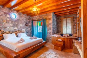 a bedroom with a bed and a tub in a room at Tetka Konukevi in Ayvalık