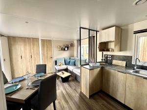 a kitchen and living room with a table and a dining room at Mobilhome in Saint-Gérons