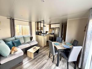 a living room with a couch and a table at Mobilhome in Saint-Gérons