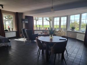 ein Wohnzimmer mit Tisch und Stühlen in der Unterkunft Dereshoeve in Bunschoten