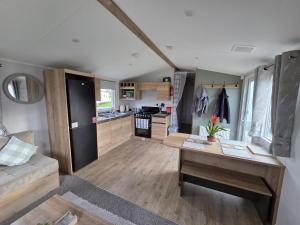 a living room with a table and a kitchen at D&A Southview getaway in Skegness