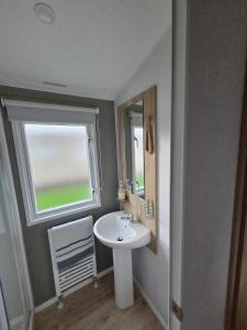 a bathroom with a sink and a window at D&A Southview getaway in Skegness