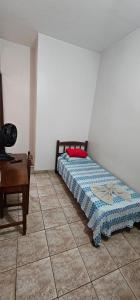 a bedroom with a bed and a desk in it at Hotel Monarca Paracatu in Paracatu