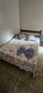 a bed with a bow tie on it in a bedroom at Hotel Monarca Paracatu in Paracatu