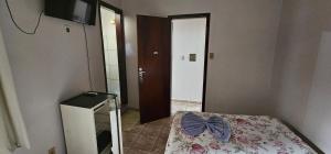 a small room with a bed with a bow on it at Hotel Monarca Paracatu in Paracatu