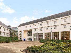 a large white building with a courtyard at Novotel Brugge Centrum in Bruges