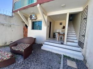 a couch and a chair sitting outside of a house at Casa do Arruda na tabuba in Caucaia