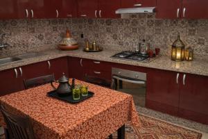 a kitchen with a table with a table cloth on it at Appartement moderne à 5 min de la plage de Mehdia Vacances idéales 2026 in Mehdiya-Plage