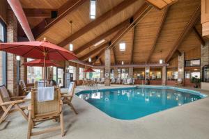 a pool with chairs and umbrellas in a building at Best Western Sycamore Inn in Oxford