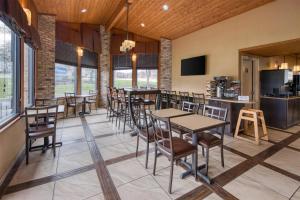 a dining room with tables and chairs and windows at Best Western Sycamore Inn in Oxford