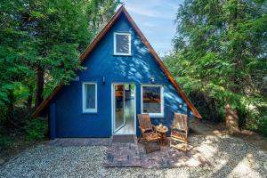 a blue cottage with two chairs and a table at Cherry garden Cseresznyéskert Vendégház in Dunabogdány