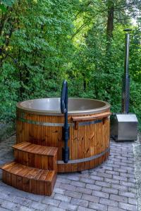 a wooden jacuzzi tub sitting on a patio at Cherry garden Cseresznyéskert Vendégház in Dunabogdány