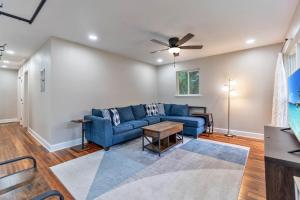 a living room with a blue couch and a ceiling fan at Hill House- Centrally Located, close to everything in Pensacola