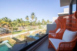 a balcony with a chair and a view of a pool at Oka Milagres Beachfront Condominium By MME in Barra do Camaragibe