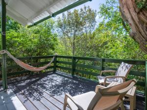 a porch with two chairs and a hammock at Trupial - The green flamingo in Willibrordus