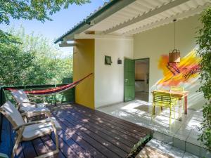 a deck with chairs and a hammock on a house at Trupial - The green flamingo in Willibrordus