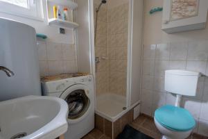a bathroom with a washing machine and a sink at Domek w Puszczy in Wiartel +63 photos