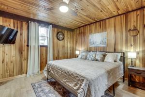 a bedroom with a bed and a tv and wooden walls at Great for Groups! Spacious Melcroft Home w/ Deck in Melcroft