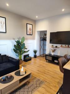 a living room with a large flat screen tv at Jardin De La Sagesse in Sotteville-lès-Rouen