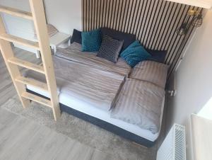 a small bed in a small room with a ladder at Apartmán Denisa in Rokytnice nad Jizerou