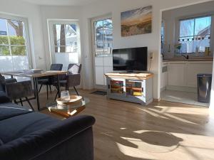 a living room with a couch and a tv and a table at Ostseemeerchen in Zingst +18 photos