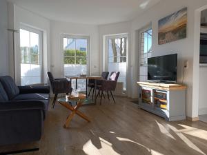 a living room with a television and a table with chairs at Ostseemeerchen in Zingst