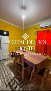 a dining room with a table and a yellow wall at Hostel Portal del Sol in Fiambalá
