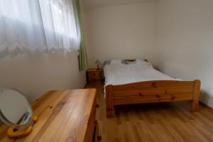 a bedroom with a bed and a mirror and a table at Domek w Puszczy in Wiartel