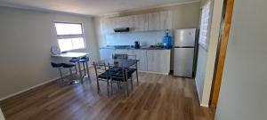 a kitchen with a table and chairs and a refrigerator at CABAÑA CON TINAJa in Guanaqueros