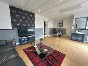 a living room with a couch and a tv at Solway Cottage in Annan